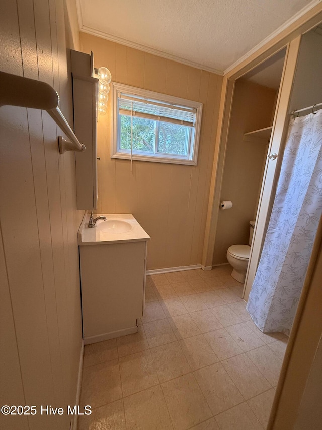 full bath with wooden walls, vanity, toilet, and crown molding