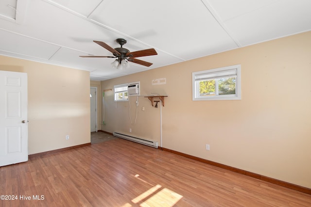 empty room featuring baseboards, ceiling fan, light wood-type flooring, a wall unit AC, and baseboard heating