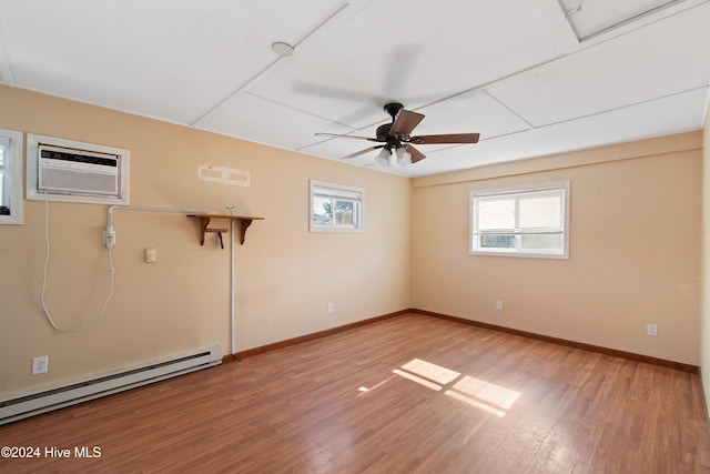 empty room with baseboard heating, light wood-style flooring, and baseboards