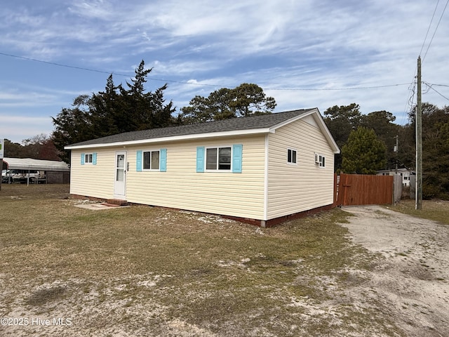 view of front of house with fence, driveway, and roof with shingles