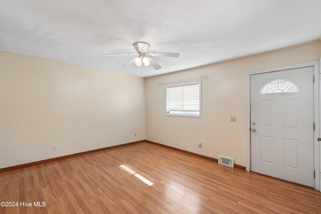 foyer with light wood finished floors, visible vents, baseboards, and a ceiling fan