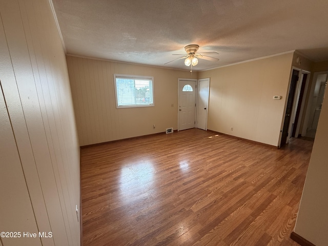 interior space featuring ornamental molding, a ceiling fan, and wood finished floors