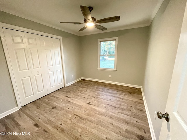 unfurnished bedroom with ceiling fan, a closet, and light hardwood / wood-style flooring