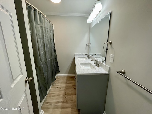 bathroom featuring vanity, hardwood / wood-style flooring, and ornamental molding