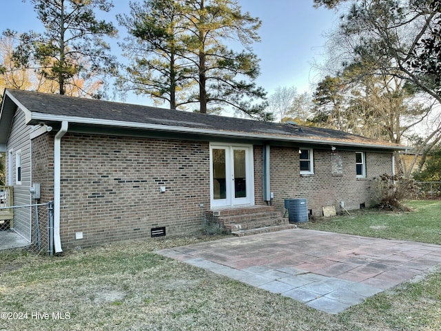 back of property featuring a yard, cooling unit, and a patio