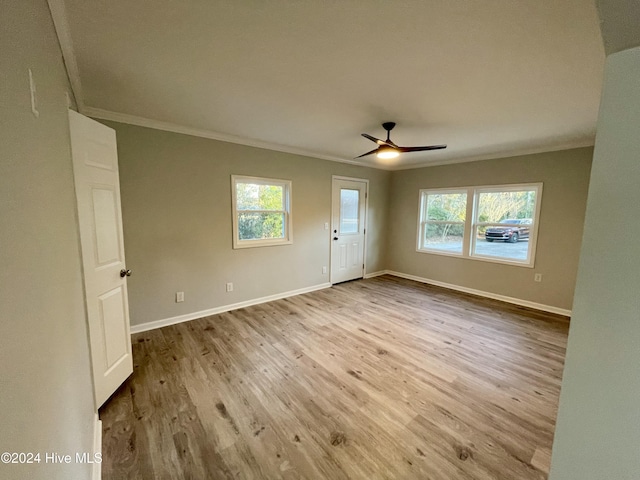 spare room featuring ceiling fan, light wood-type flooring, and crown molding