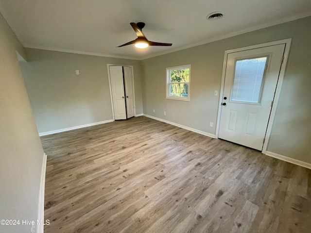 unfurnished bedroom featuring light hardwood / wood-style floors, ceiling fan, and crown molding