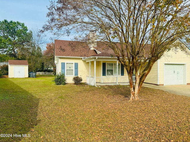 view of front facade with covered porch, a garage, a front lawn, and a storage shed