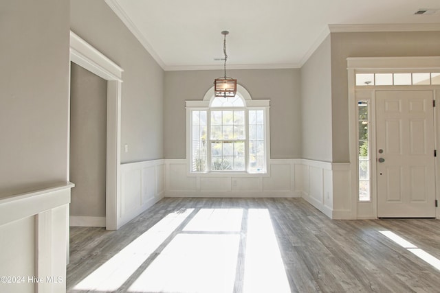 entryway with crown molding and light hardwood / wood-style flooring