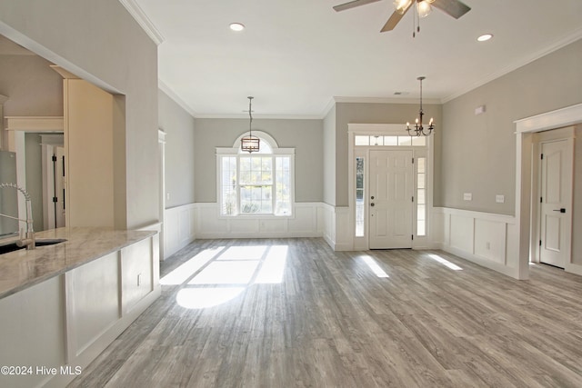 foyer entrance with crown molding, sink, and light hardwood / wood-style floors