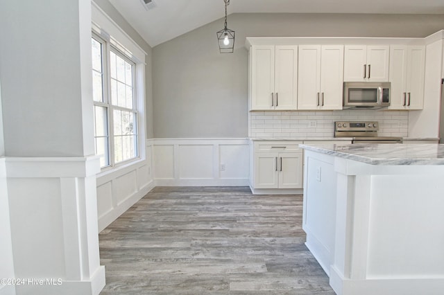 kitchen featuring white cabinets, plenty of natural light, appliances with stainless steel finishes, and tasteful backsplash