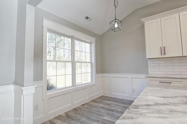 unfurnished dining area with light hardwood / wood-style floors and vaulted ceiling