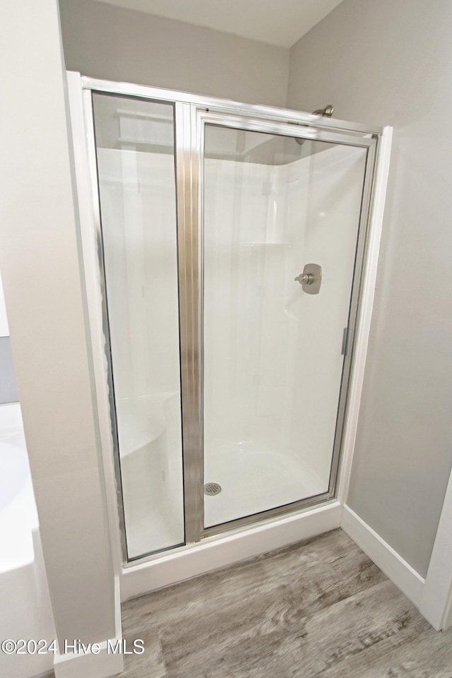 bathroom featuring a shower with door and wood-type flooring