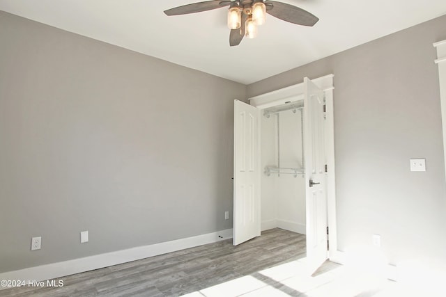 unfurnished bedroom with a closet, ceiling fan, and hardwood / wood-style floors