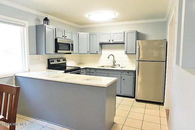 kitchen with kitchen peninsula, appliances with stainless steel finishes, crown molding, sink, and gray cabinets