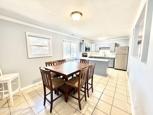 tiled dining room featuring ornamental molding and sink