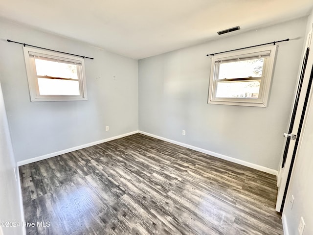 unfurnished room with dark hardwood / wood-style floors and a wealth of natural light