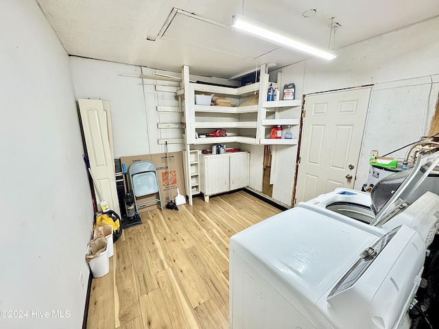 laundry room with light hardwood / wood-style floors and washer and clothes dryer