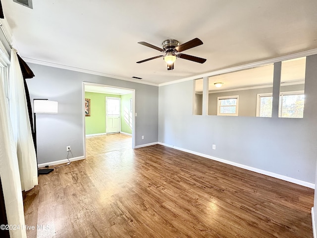 unfurnished room with a wealth of natural light, ceiling fan, ornamental molding, and hardwood / wood-style flooring