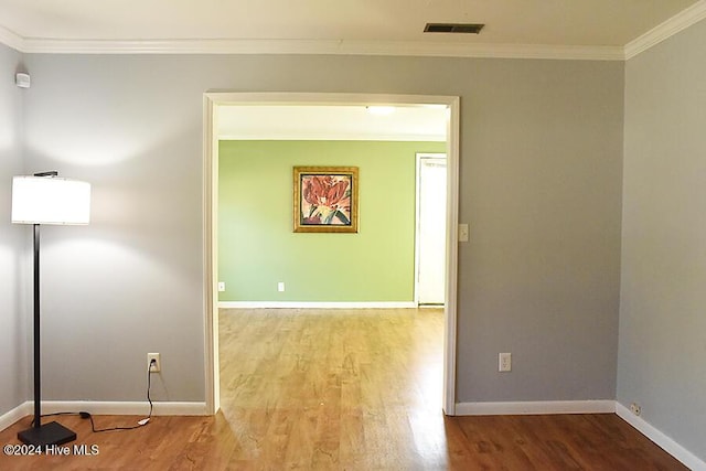 spare room with wood-type flooring and ornamental molding