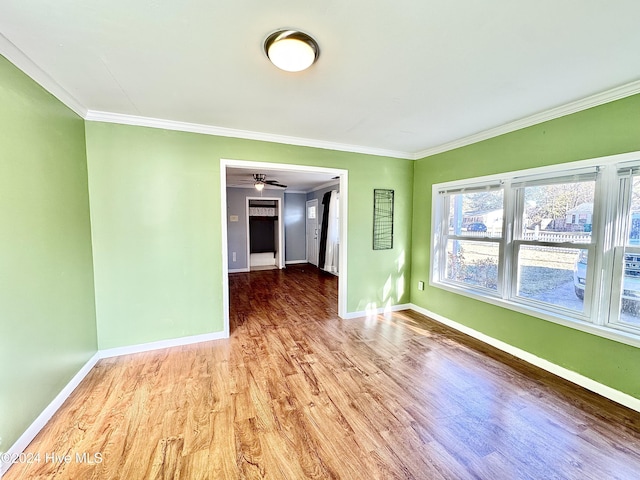 empty room featuring crown molding, ceiling fan, and wood-type flooring