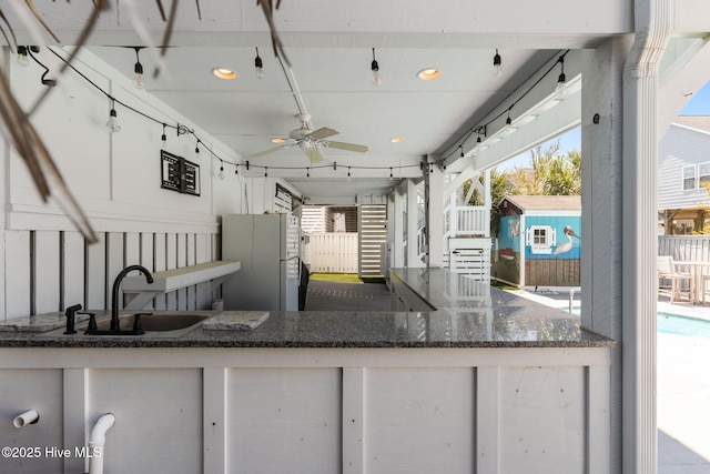 view of patio featuring a ceiling fan and a sink