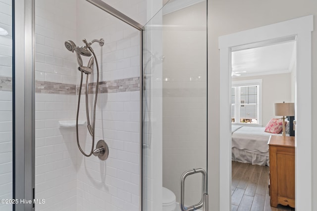 full bathroom with a stall shower, wood finished floors, ornamental molding, and ensuite bathroom