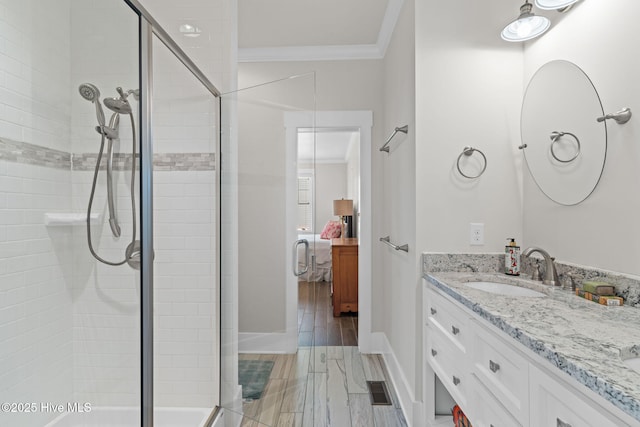 ensuite bathroom with a sink, connected bathroom, crown molding, a stall shower, and visible vents