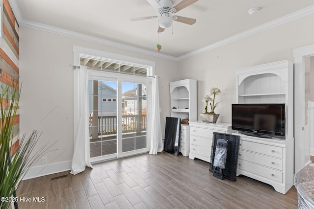 interior space featuring ornamental molding, ceiling fan, and wood finished floors