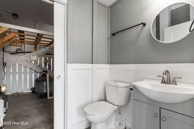 bathroom with toilet, concrete floors, and vanity