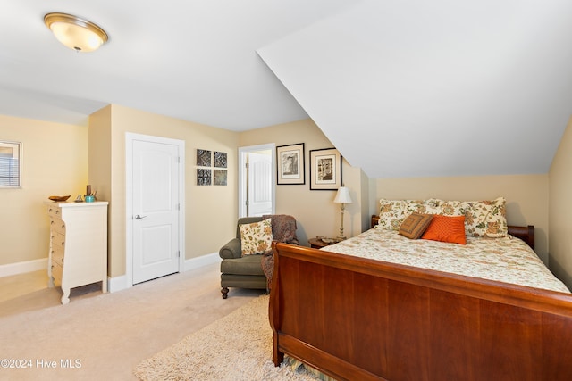 bedroom with light colored carpet and vaulted ceiling