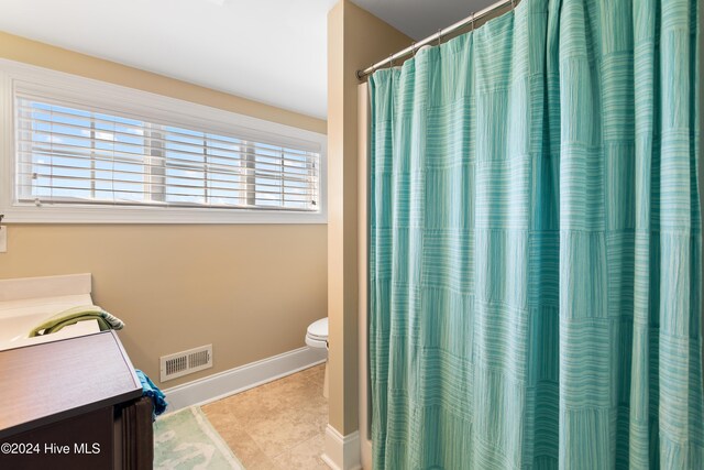 bathroom featuring tile patterned floors, plenty of natural light, vanity, and toilet