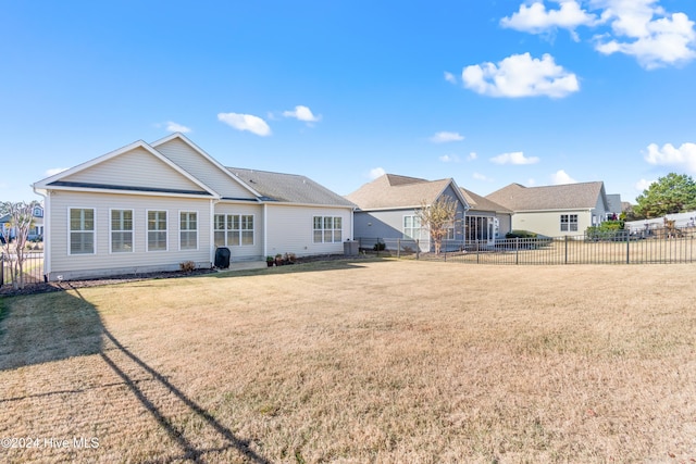 rear view of property featuring a lawn