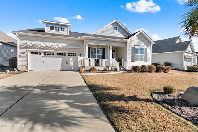 view of front of property featuring covered porch, a front yard, and a garage