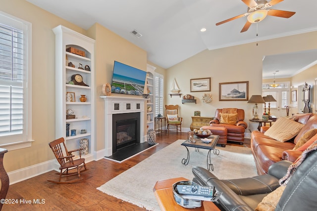 living room featuring plenty of natural light, crown molding, dark wood-type flooring, and ceiling fan with notable chandelier