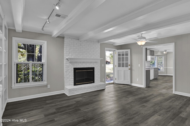 unfurnished living room featuring beamed ceiling, dark hardwood / wood-style flooring, and plenty of natural light