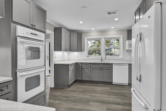 kitchen featuring white appliances, dark hardwood / wood-style floors, ornamental molding, and sink