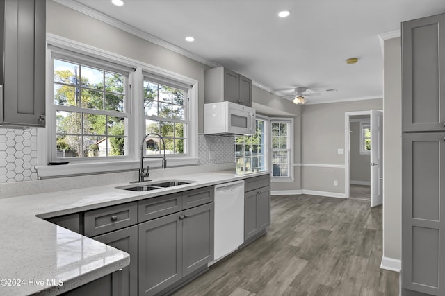 kitchen featuring decorative backsplash, white appliances, a wealth of natural light, and sink