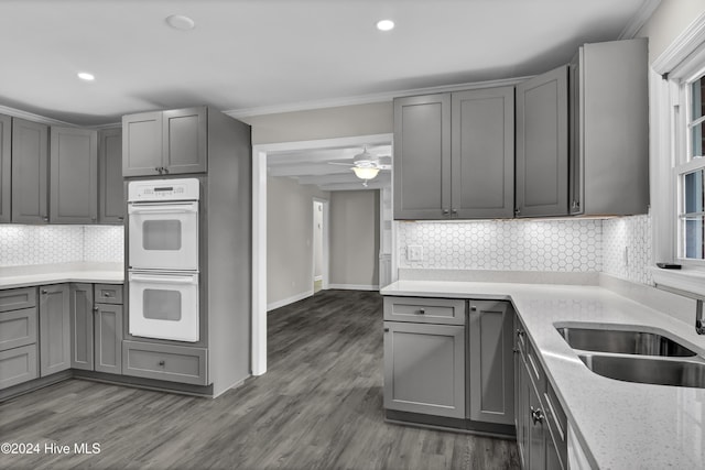 kitchen featuring decorative backsplash, dark hardwood / wood-style flooring, double oven, and gray cabinetry