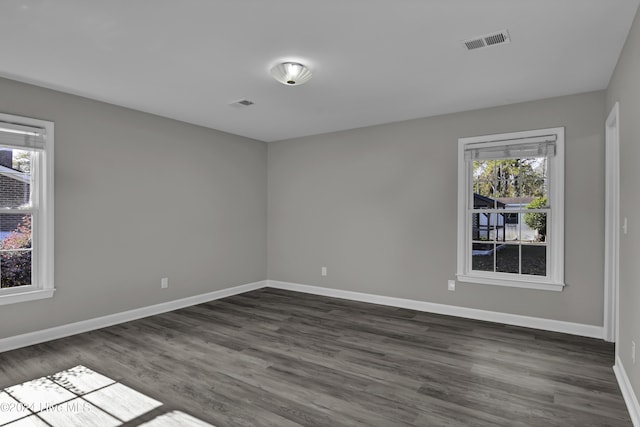 unfurnished room with dark wood-type flooring