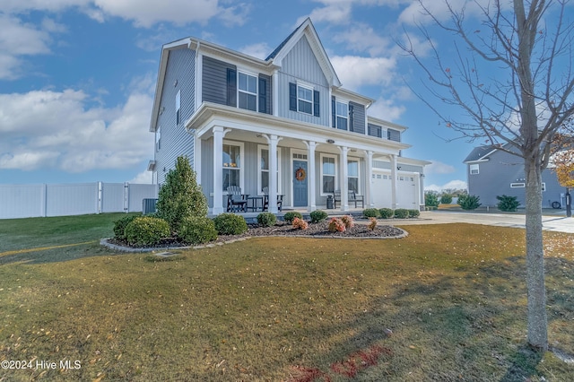 view of front of home with a porch, cooling unit, a front yard, and a garage