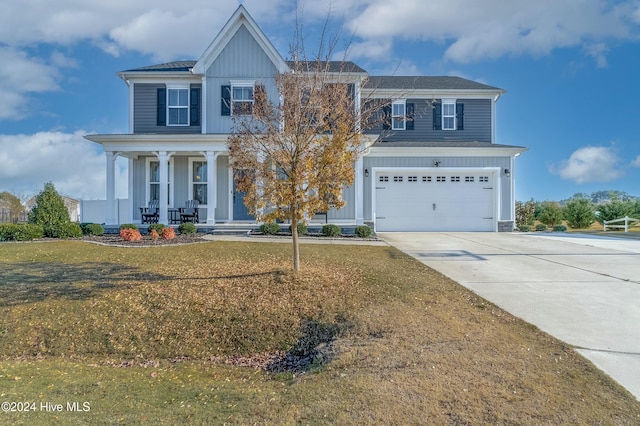 view of front facade with covered porch, a garage, and a front yard