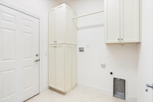 laundry area featuring cabinets, hookup for a washing machine, light tile patterned floors, and electric dryer hookup