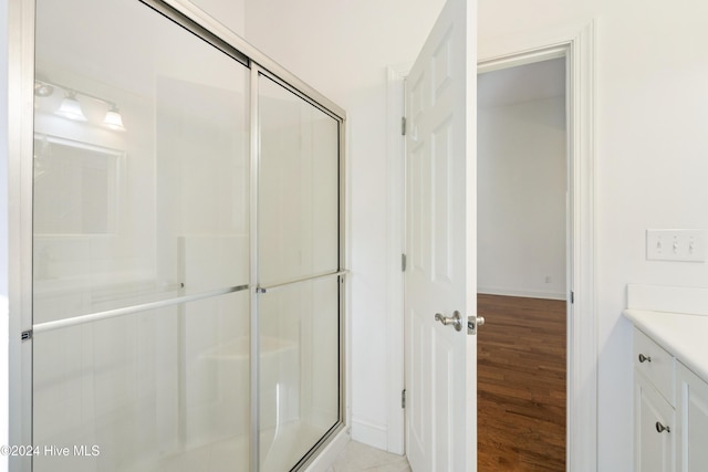 bathroom with vanity, wood-type flooring, and an enclosed shower