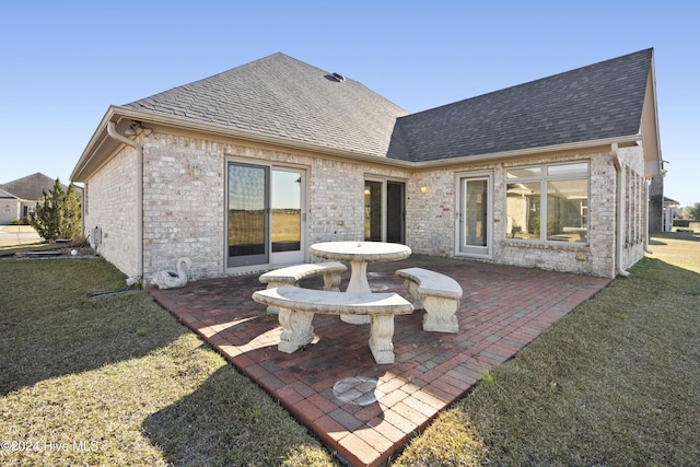 back of property featuring a yard and a patio