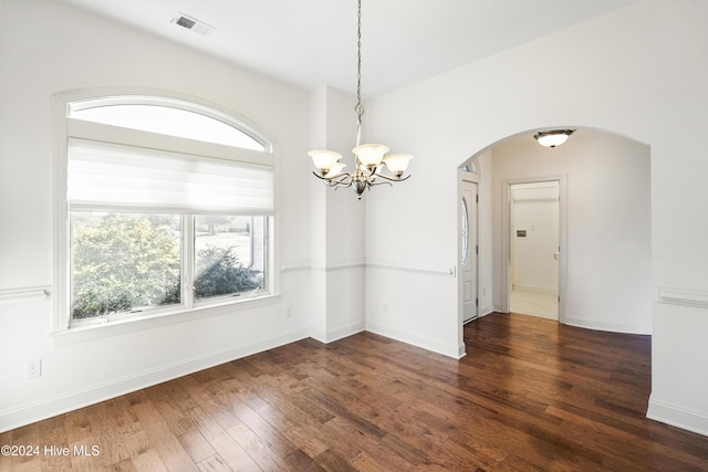 unfurnished dining area featuring a notable chandelier and dark wood-type flooring