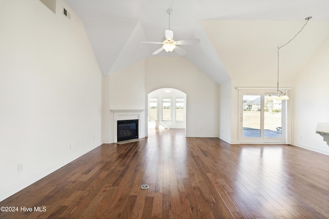 unfurnished living room with ceiling fan, plenty of natural light, high vaulted ceiling, and dark wood-type flooring