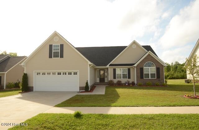 view of front of house featuring a garage and a front lawn