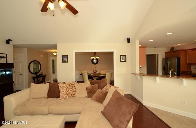 living room featuring ceiling fan and lofted ceiling