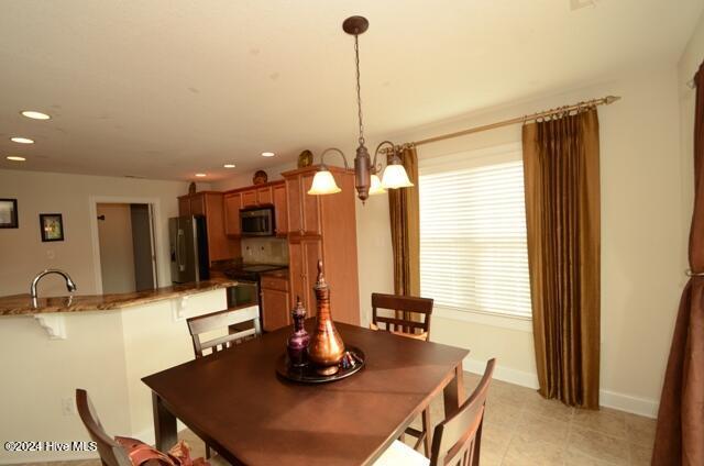 dining room featuring sink and a chandelier